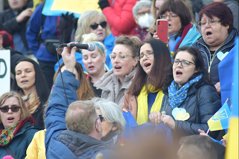 Ukrainian residents of Victoria sing the Ukrainian national anthem on the steps of the B.C. Legislature, Feb. 27, 2022. (Kiernan Green/News Staff)