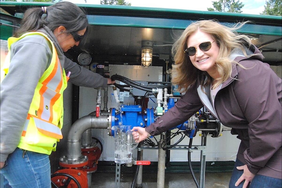 Electoral Area G (Englishman River, San Pareil, French Creek, Little Qualicum, Dashwood) director Lehann Wallace draws clean water from the new water metering system located near the Sandpiper water reservoir. (Michael Briones photo)