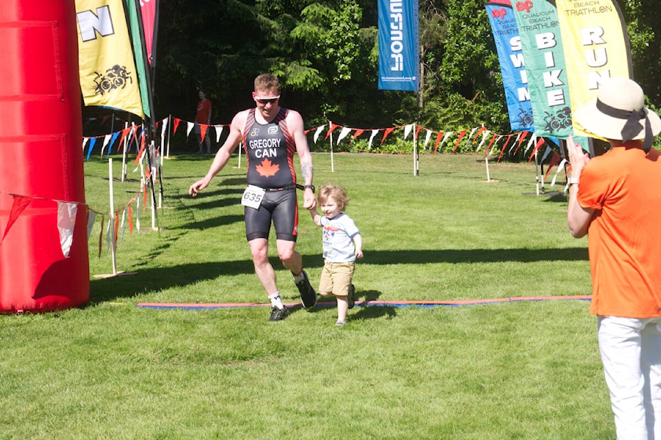 Mike Gregory was joined by his son, Jack, as he ran across the finish line at the Qualicum Beach Triathlon June 26, 2022. (Kevin Forsyth photo)