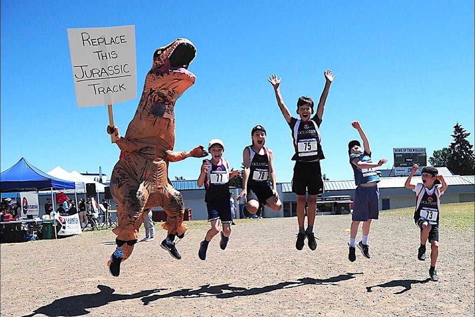 T-Rex with No. 77 Olivia Bewsey, No. 78 Ethan Bewsey, No. 75 Johnan Kolen-Lee, No. 71 Declan Binder and No. 73 Thomas Luksay got the Community Love Run jumping in excitement. (Michael Briones photo)