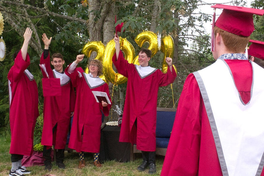 Left to right: Dagen de Waal, Liam Scoffings and Hayden Farand celebrate their graduation from Kwalikum Secondary School on June 29, 2022. (Kevin Forsyth photo)