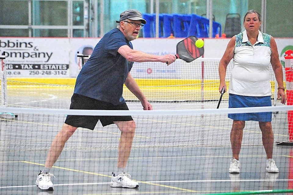 Jeff Gifford makes a backhand shot while Linda Witzke keeps her eyes on the ball. They finished third in the D Division. (Michael Briones photo)