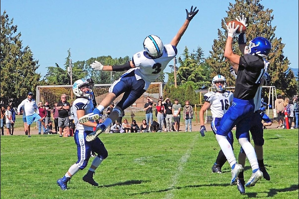 Ballenas Whalers Carter Brett hauls in a pass while a Belmont Bulldog jumps high in attempt to intercept it. (Michael Briones photo)