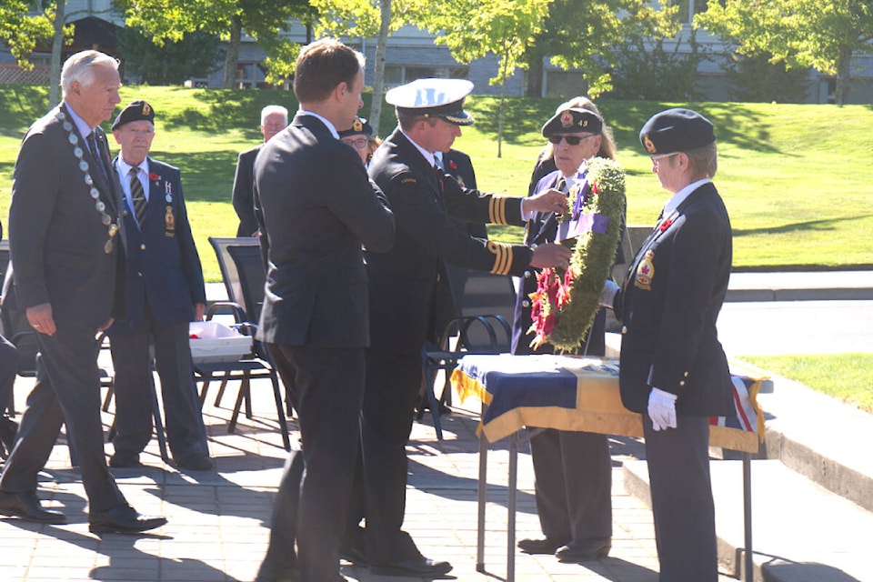 Cmdr. Craig Piccolo, CFMETR Nanoose, places a poppy on a wreath during a ceremony for Queen Elizabeth II at the Parksville Cenotaph on Sept. 19. (Kevin Forsyth photo)