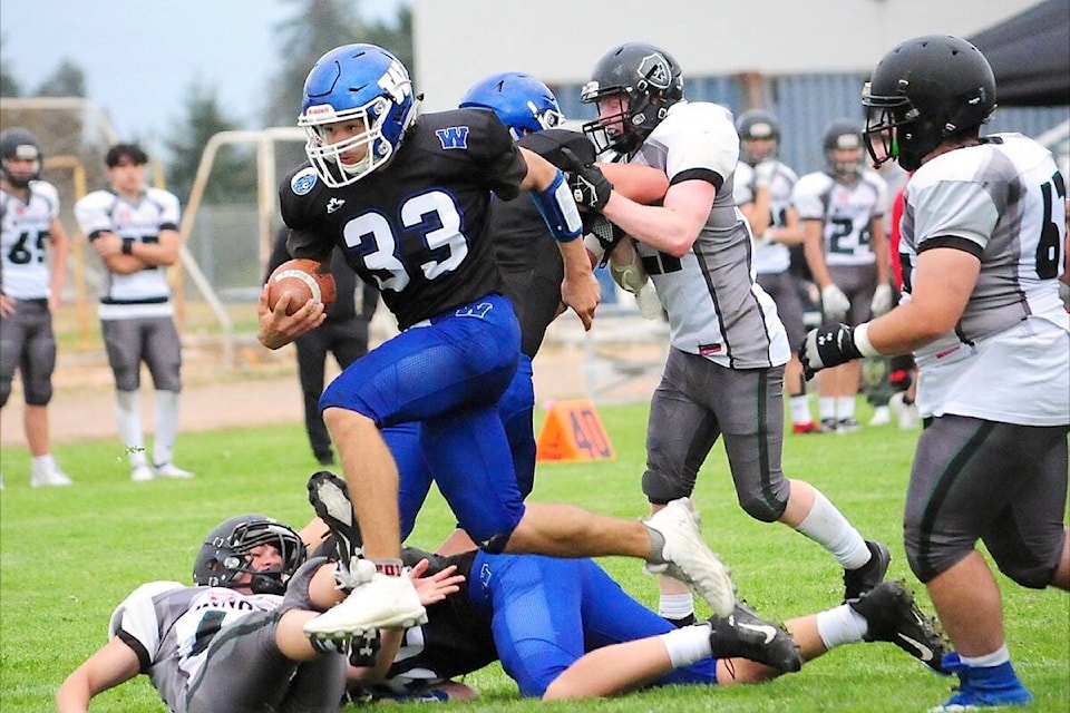 Ballenas Whalers player Damon Stone jumps over players as he tries to advance the ball against Windsor Dukes. (Michael Briones photo)