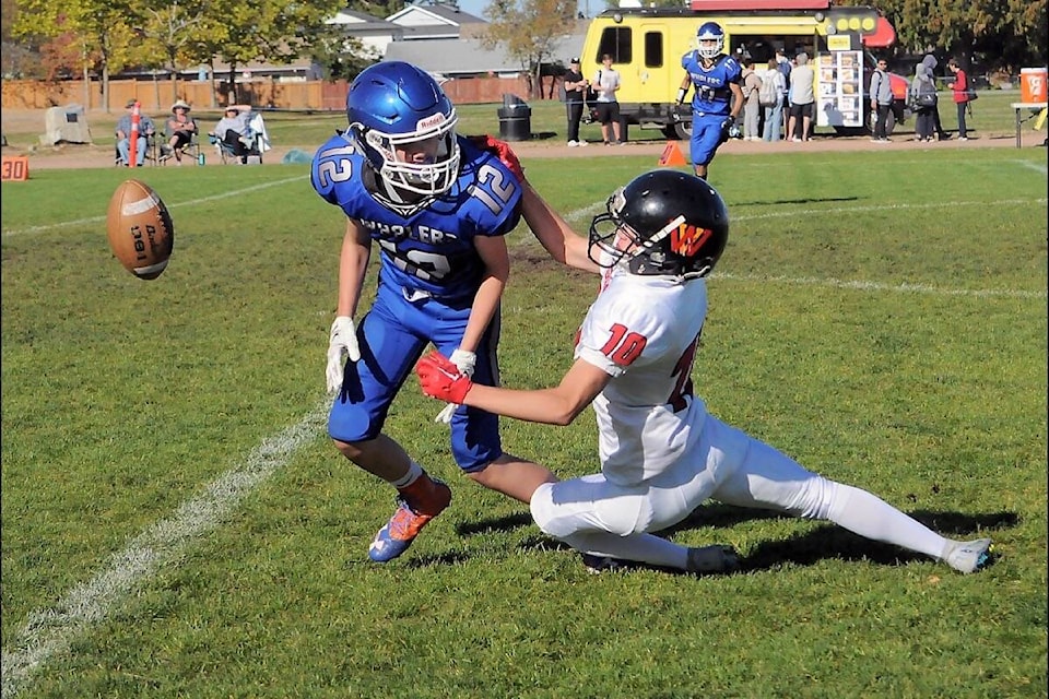 Ballenas Whalers defensive back Jaden Dusomme forces a West Van Highlander to cough up the ball. (Michael Briones photo)