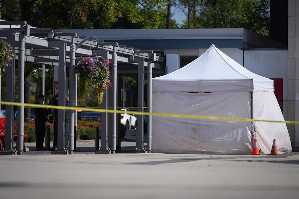 Police officers talk while standing near an evidence tent outside the Queen Elizabeth Theatre in Vancouver, on Wednesday, September 4, 2024. Vancouver police say a man has been arrested in connection with two serious incidents that happened between 7:30 a.m. and 7:45 a.m. in the downtown area and that the investigation is ongoing. 