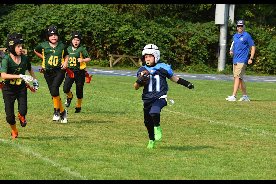 Atom White Rock South Surrey Titans player Charlie Bray with the ball, on his way to scoring a touchdown for the team, who won 18-7 over the South Delta Rams.
