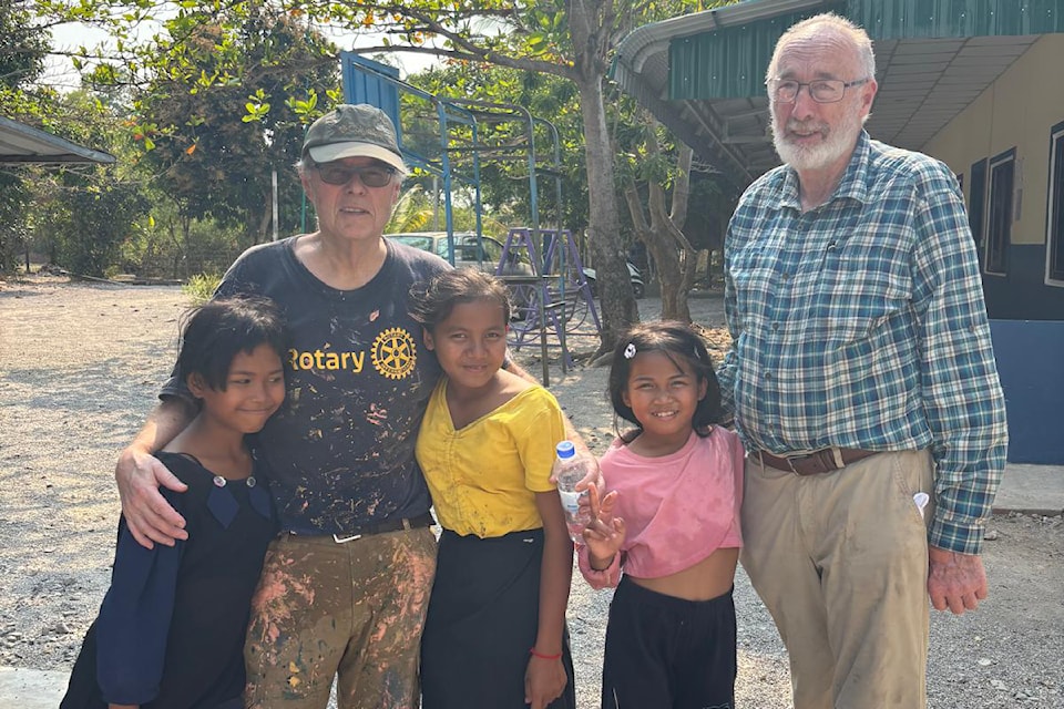 Rotarians Doug Baker (left) and Brian O'Ruairc pose with some of the children who live at the Happy Home Children's Centre in Cambodia.