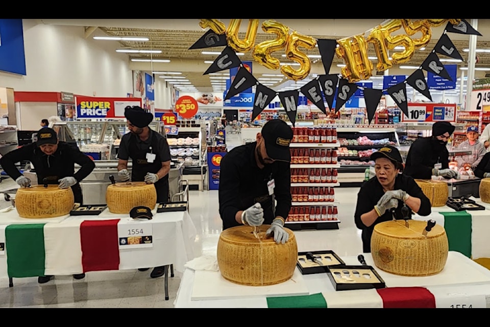 Store staff crack wheels of Parmigiano Reggiano at the Real Canadian Superstore in Delta June 14 to help break a Guinness World Record.