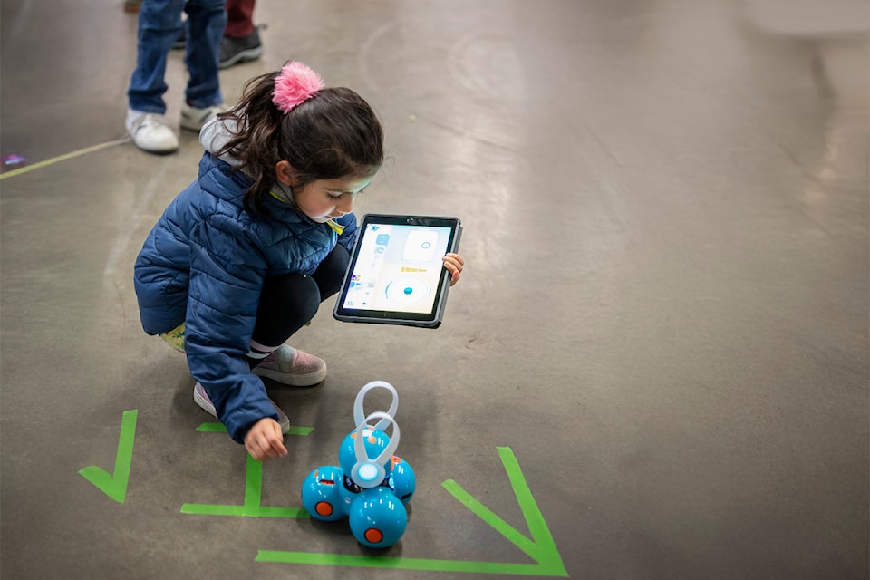 surrey-libraries-a-child-learns-basic-coding-skills-while-playing-with-a-dash-robot-and-tablet