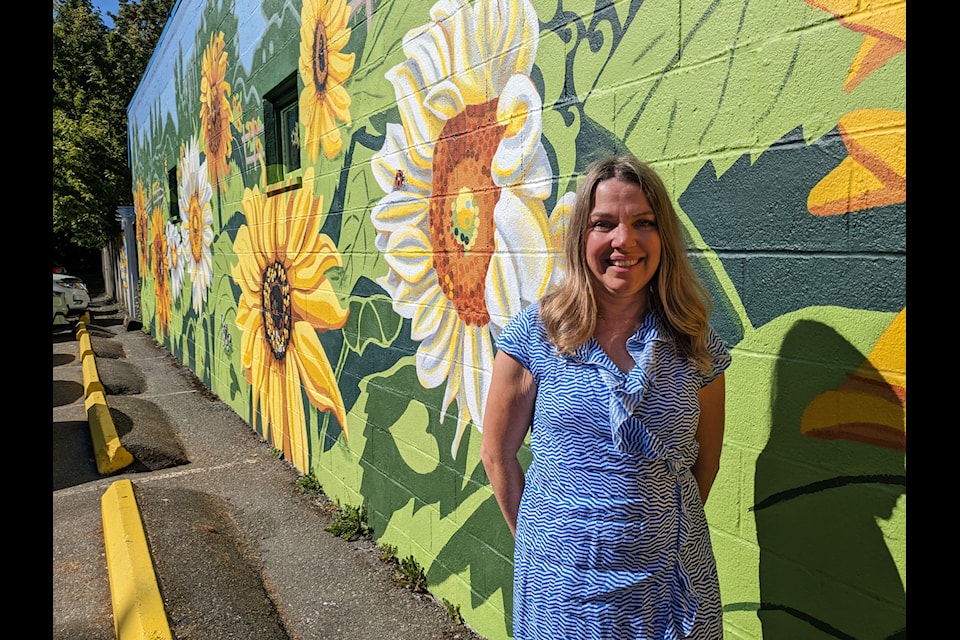 Artist Carla Maskall beside her mural at Crescent Beach's iconic Sunflower Cafe.  