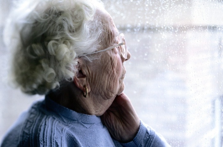 Elderly Woman Looking Out a Window