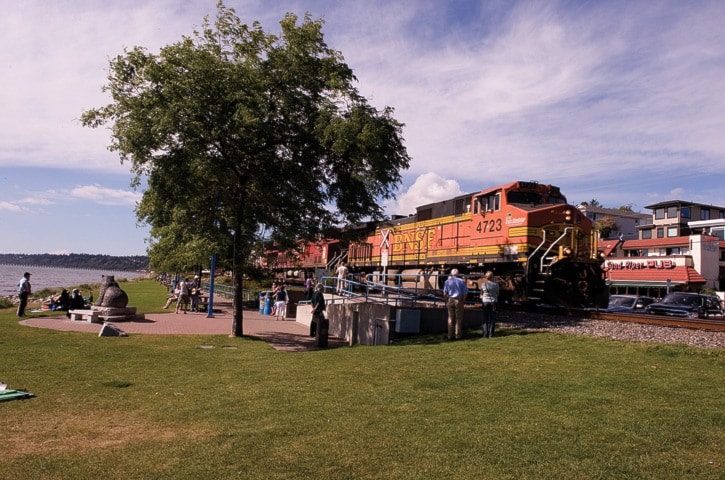 BNSF freight train going past East Beach with people on the promenade.