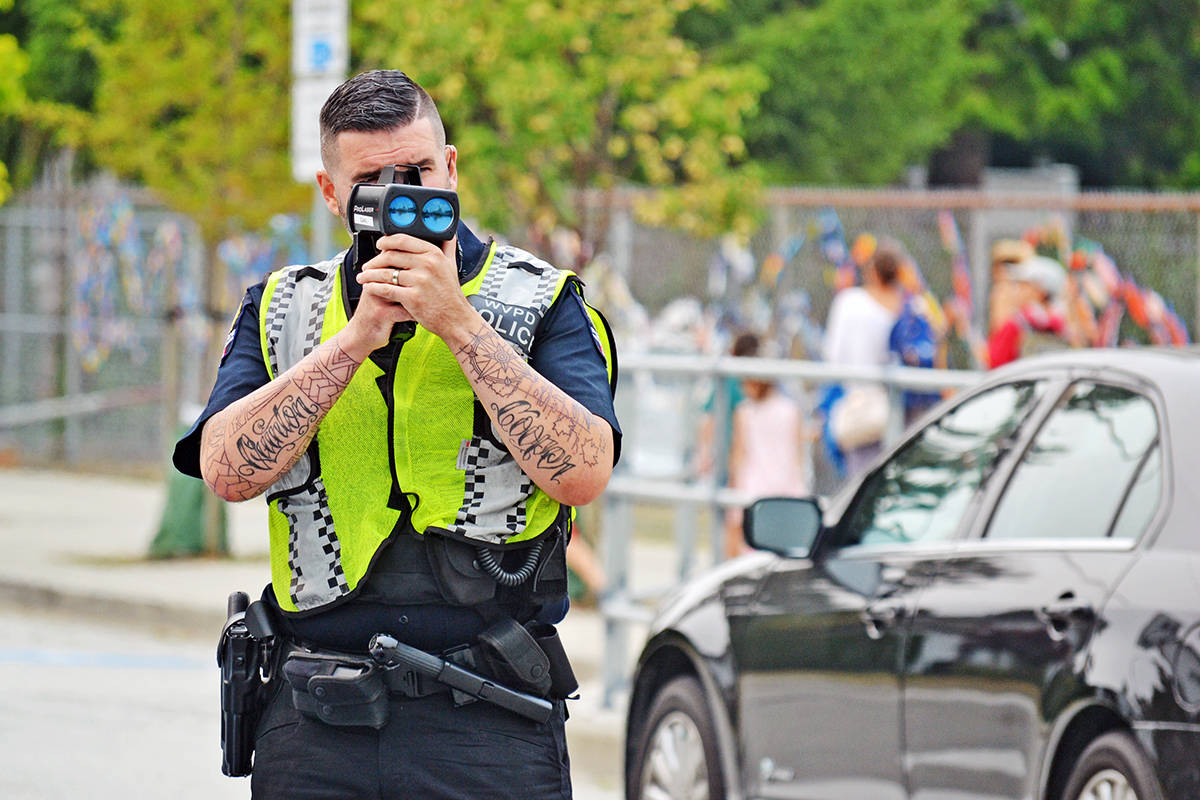 Tracy Holmes photo Const. Brock Harrington of the Integrated Road Safety Unit users a laser to check the pace of an oncoming car outside Peace Arch Elementary Thursday afternoon.