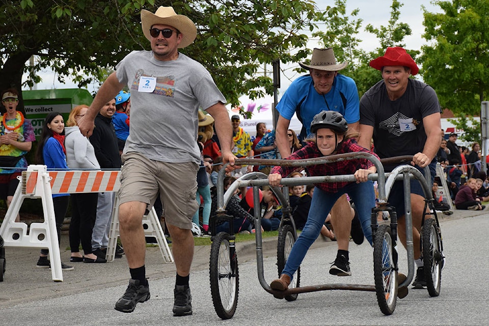 Aaron Grim (left), George Gunnik, and Bryan Grim push Morgan Grim in the team’s new bed racer down 176A Street during the 42nd annual Cloverdale Bed Race in 2019. Grim repurposed his old bed racer from 2018 into a movable chicken coop. (Black Press file photo)
