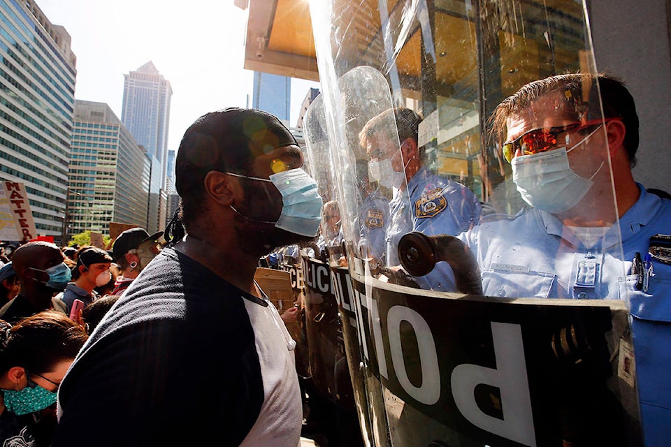 A protester and a Philadelphia Police officer look at each other during a Justice for George Floyd rally at the MSB on Saturday, May 30, 2020, in Philadelphia. Floyd died in Minneapolis police custody on May 25. (Yong Kim/The Philadelphia Inquirer via AP)