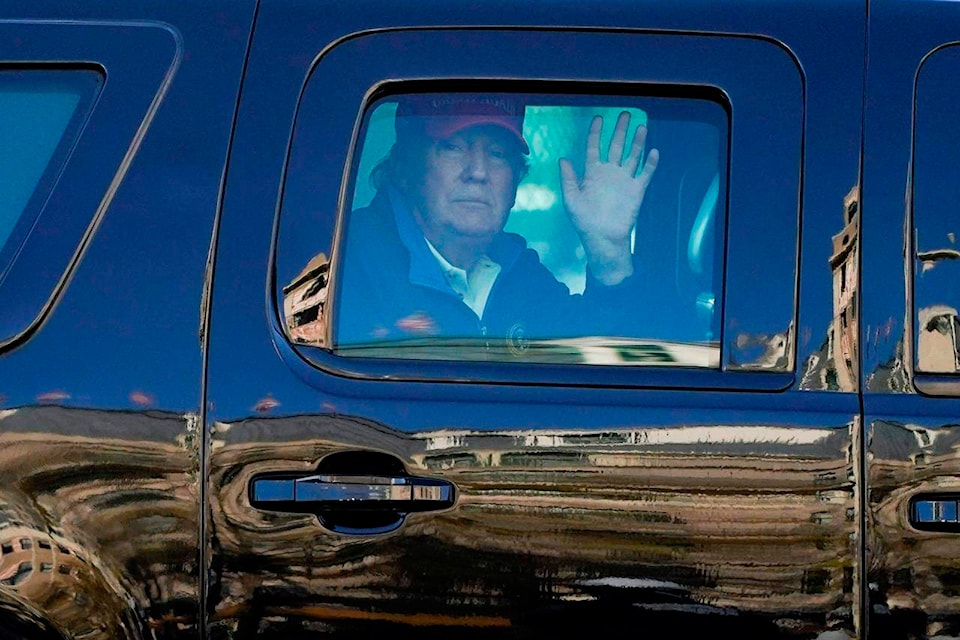 President Donald Trump waves to supporters from his motorcade as people gather for a march Saturday, Nov. 14, 2020, in Washington. (AP Photo/Julio Cortez)