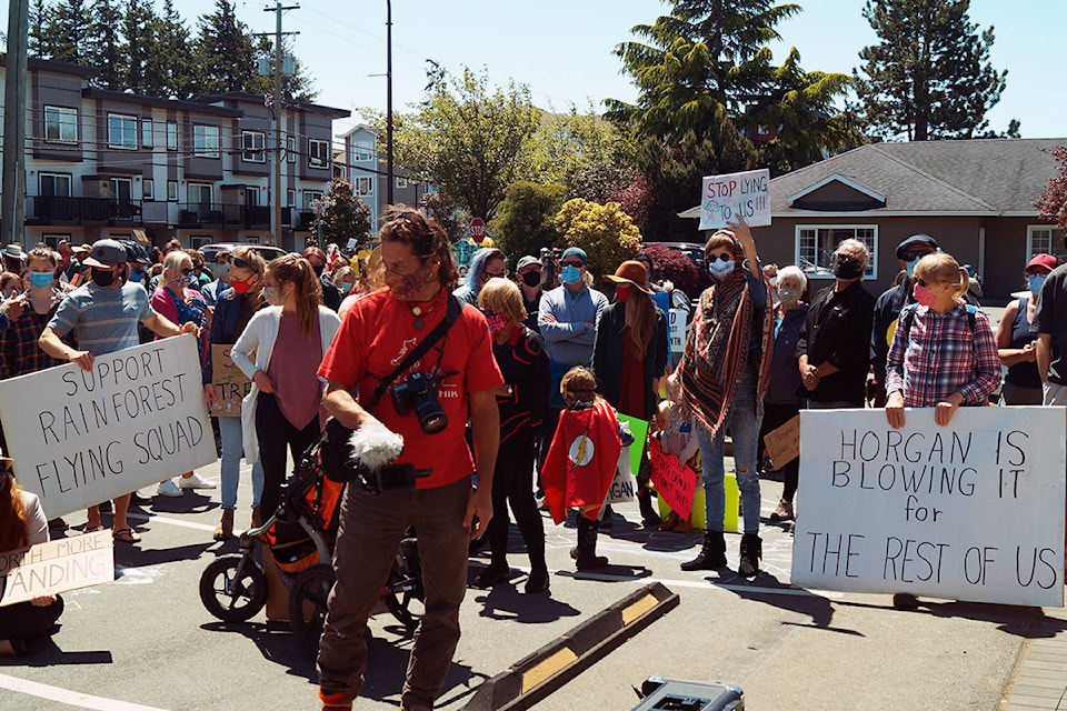 Protesters gather outside Premier John Horgan’s constituency office in Langford on Friday to protest the logging of old-growth forests. (Rick Stiebel/News Staff)