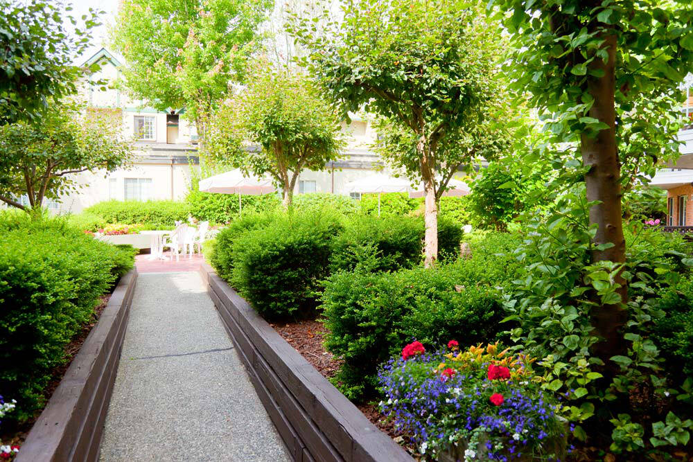 Residents enjoy the beautifully landscaped grounds at Pacific Carlton seniors residence.