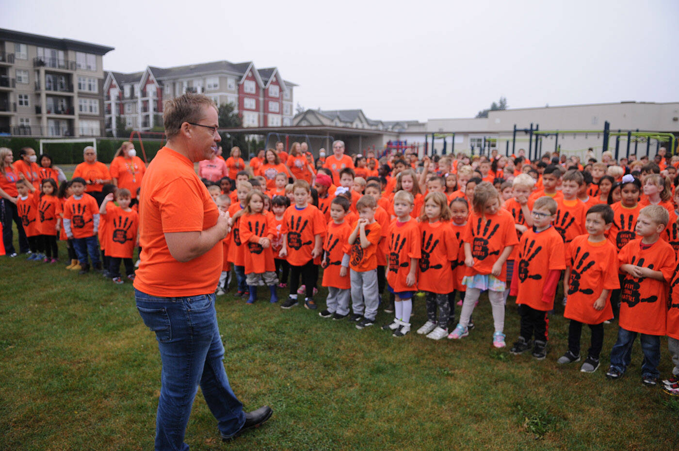 Bernard Elementary principal Brad Johnston speaks to students as they gather for a group photo outside the school on Thursday, Sept. 29, 2022. The schools parent advisory council bought an orange T-shirt for every single student at Bernard. (Jenna Hauck/ Chilliwack Progress)