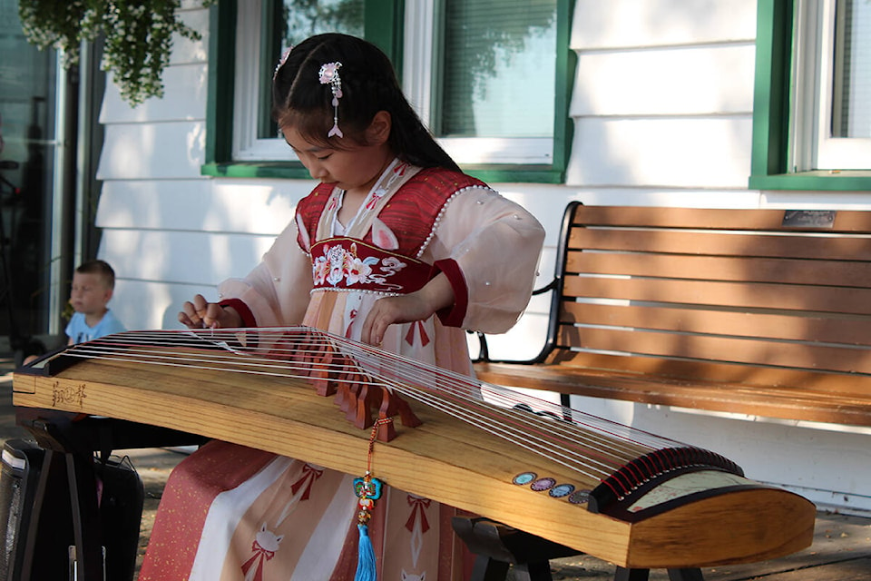 Annie Qi plays the Guzheng, a traditional Chinese instrument at the White Rock promenade and collects donations for the BC Children’s Hospital. (Sobia Moman photo)