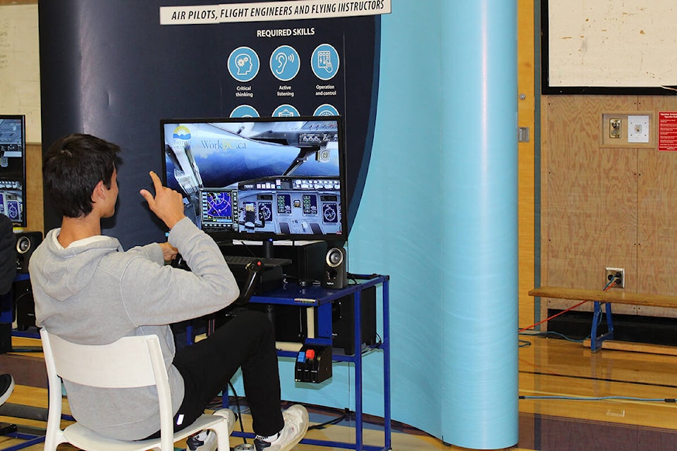 Elgin Park Secondary students explore all of the different career options presented to them for WorkBC’s ‘Find Your Fit’ event. Mattia Trentanove operates a flight simulator. (Sobia Moman photo)