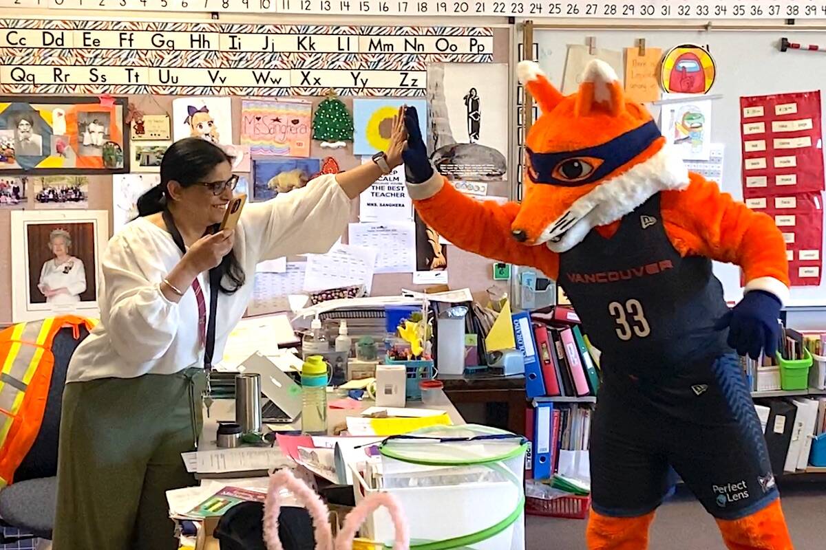 Vancouver Bandits pro basketball team mascot Berry the Bandit high-fives a teacher at Creekside Elementary during a visit to the Surrey school on Thursday, June 8, 2023. (Photo: Tom Zillich)