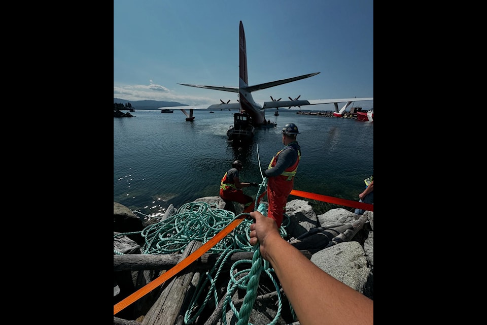 Crews work to 'dewater' the Hawaii Mars ahead of the massive water bomber's careful move across North Saanich to the BC Aviation Museum.