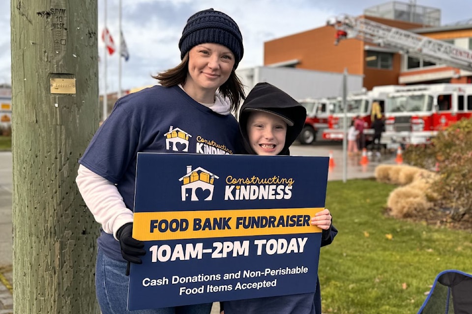 Volunteers Julia Johnston and Dylan Velikovsky standing on the roadside to promote Constructing Kindness to motorists.