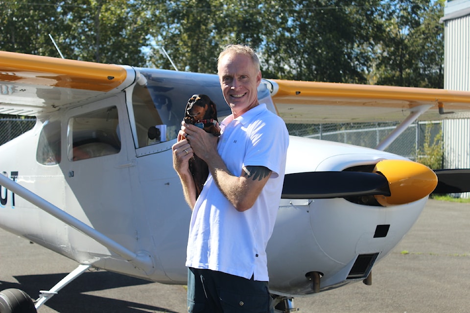 Jayson Biggins and his dog Luna next to his aircraft.