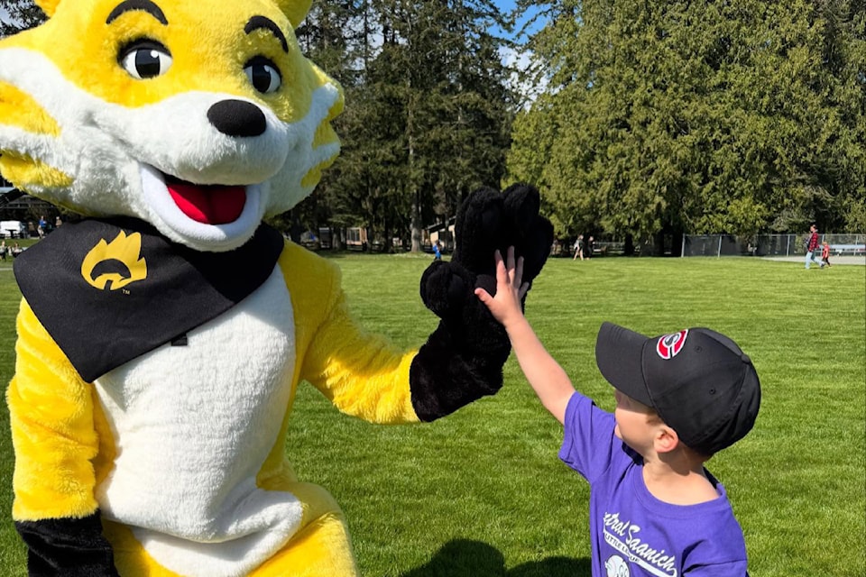 A young player high-fives Ember the FireSmart mascot during opening day for Central Saanich Little League on April 12.