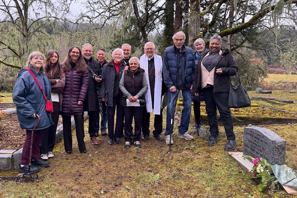 Darleene Horricks stands in the center of a group of family and friends after a ceremony at her maternal great-grandmother's grave.