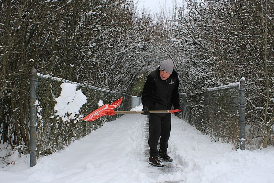 Marcus Durrant shoveling snow on a path by the West Sidney bike path.