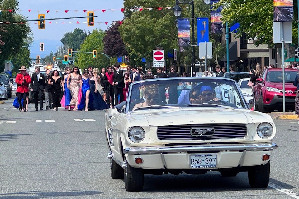 A vintage car leads the Grad Walk convoy on Beacon Avenue.
