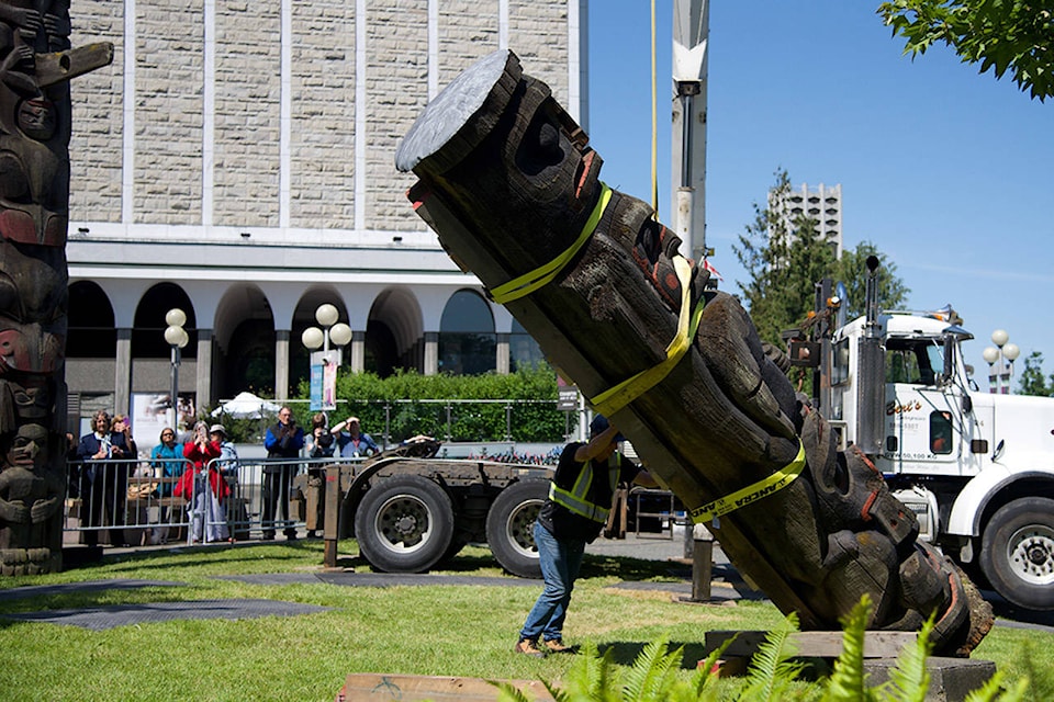 Workers carefully placed the totem down as it was removed from the place it stood for 65 years (Nicole Crescenzi/ News Staff)