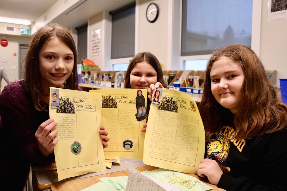 Grade 5 Lakewood Elementary students Riley Bloey (left), Serenity Vrebosch and Maddi Wall take a look at the student submissions for the 1995 time capsule. (Aaron Guillen/News Staff)