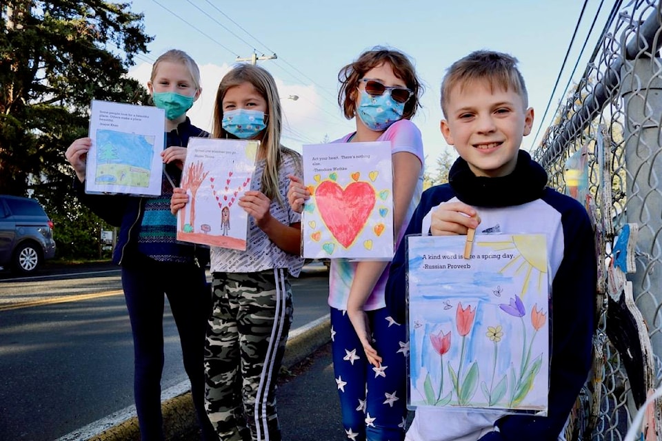 Sangster Elementary Grade 4 students Ryker de Ruiter (right), Temperance Walker, Lyla Wiltse and Ella Baxter-Mohrmann show the artwork that their class created to spread positivity in Colwood. (Aaron Guillen/News Staff)