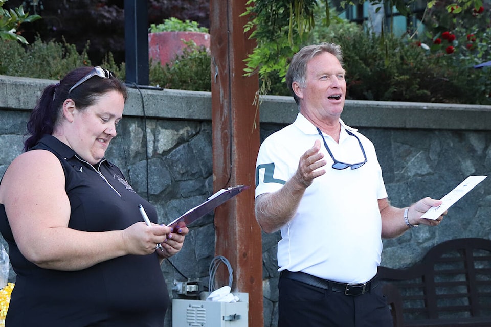 Langford Mayor Stew Young, accompanied by tournament coordinator and city staffer Terri Foggitt, plays the role of auctioneer following the 25th annual Mayor’s Charity Golf Classic at Bear Mountain Resort on Wednesday. (Don Descoteau/News Staff)