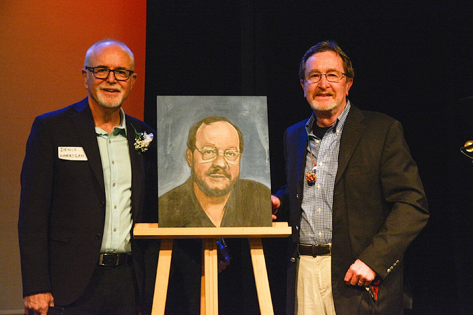 Denis Harrigan (left), former principal at Spectrum Community School, and Phil Watt, a former teacher at Spectrum and alumni board member. The two men stand with a portrait of their late colleague, Brian Whitmore. (Photo courtesy of Michelle Rachel)