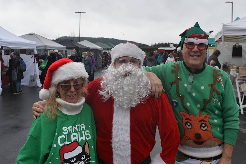 Lori McDermid and Darren Westwood flank Santa Claus during the inaugural Sidney Outdoor Christmas Market held Sunday in the parking lot of Sidney’s Mary Winspear Centre. (Wolf Depner/News Staff)