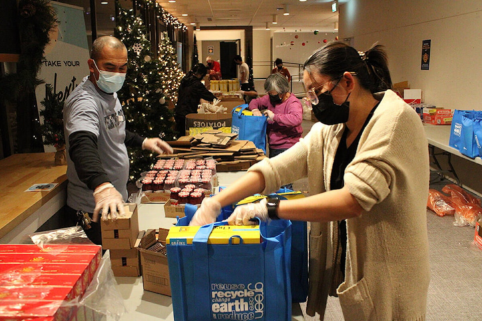 Volunteers pack food items and holiday treats into bags for GT Church’s Christmas Hamper Outreach program on Dec. 14. (Jake Romphf/News Staff)