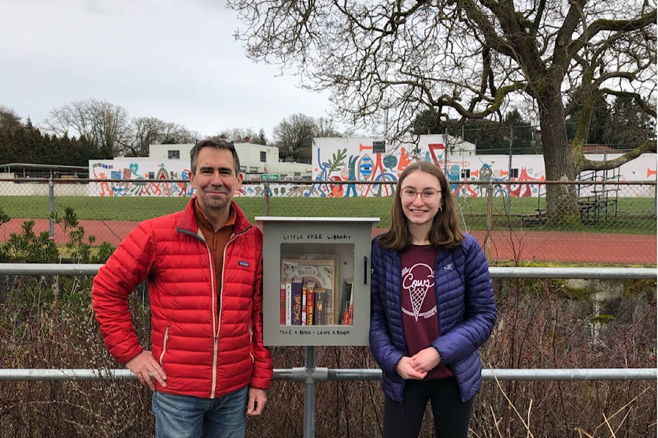 Sidney Hurst (right) and her father Steven Hurst stand with the little free library the teen built as part of her graduation capstone project at Oak Bay High. (Photo by Sarah Nguyen)
