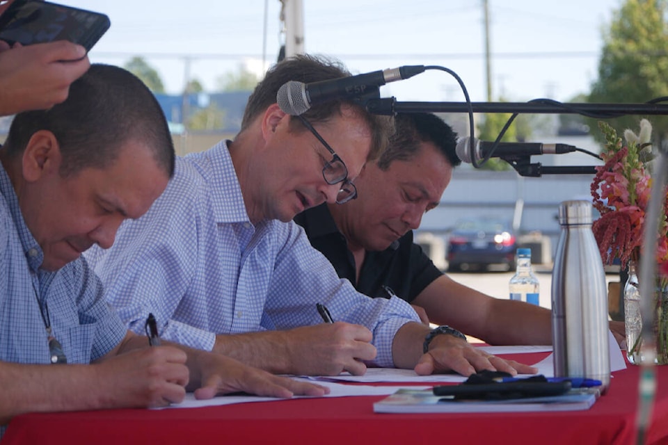 Songhees Chief Ronald Sam (from left), BC Hydro CEO Chris O’Riley and Esquimalt Chief Robert Thomas sign papers transferring 4.5 acres of land in Rock Bay to Matullia Holdings LP, which represents both the Esquimalt and Songhees First Nations, in a ceremony held Tuesday (July 26) at the site. (Evert Lindquist/News Staff)