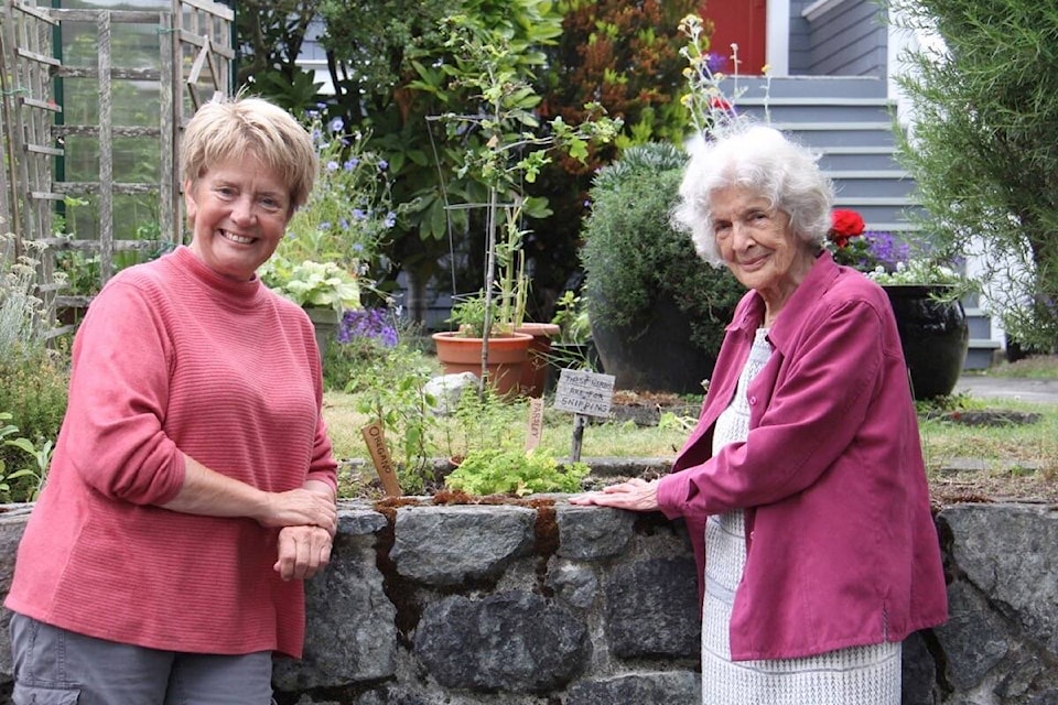 Barbara Holst, right, calls the herb garden fronting Jude Somers’ Oak Bay home a magical place. (Christine van Reeuwyk/News Staff)