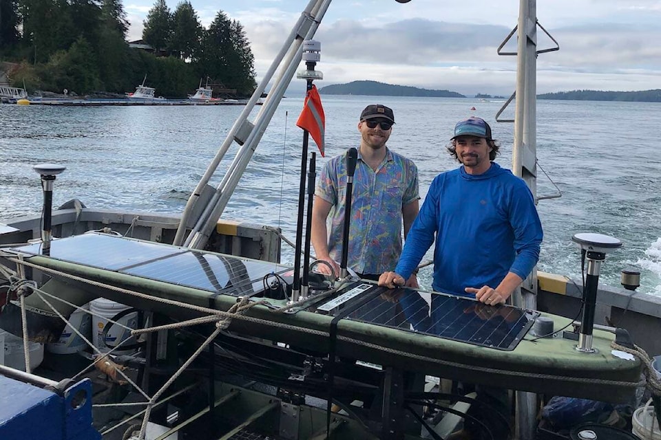 Ocean Network Canada field services manager Dirk Brussow and senior project engineer Nicolai Bailly with the recovered wave glider from the seafloor geodesy system project. (Courtesy of Ocean Networks Canada)