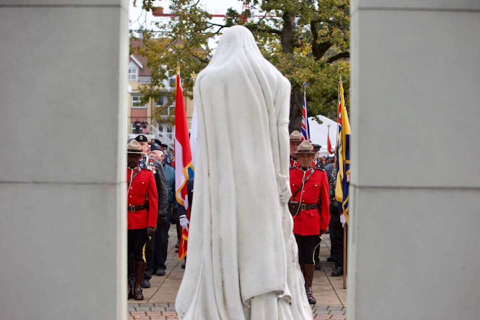 Parade members are seen through the cenotaph at Veterans Memorial Park Friday, Nov. 11, during the 2022 Remembrance Day ceremony in Langford. (Justin Samanski-Langille/News Staff)