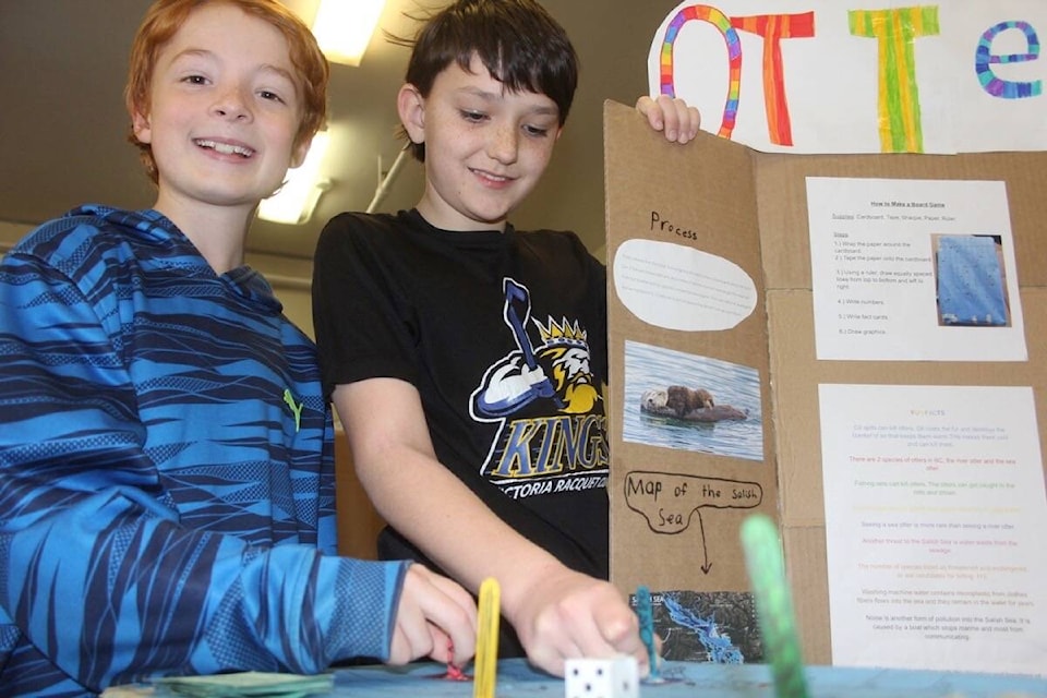 Rory Humphries and Ethan Bell (pictured) along with Max Boquist (not pictured) created a board game, similar to snakes and ladders with spaces where players learn facts about the Salish Sea. (Christine van Reeuwyk/News Staff)