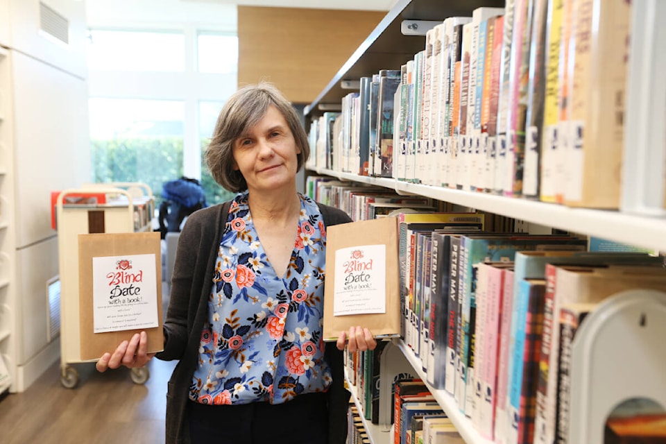 Sharon Walker, manager of the Sidney/North Saanich branch of the Vancouver Island Regional Library, shows off a pair of wrapped books for the branch’s Blind Date with a Book special section, which is available until Feb. 18. The initiative invites readers to choose a secret book based only on a description, not knowing exactly what they will be reading until they check out the book and unwrap it at home. (Justin Samanski-Langille/News Staff)