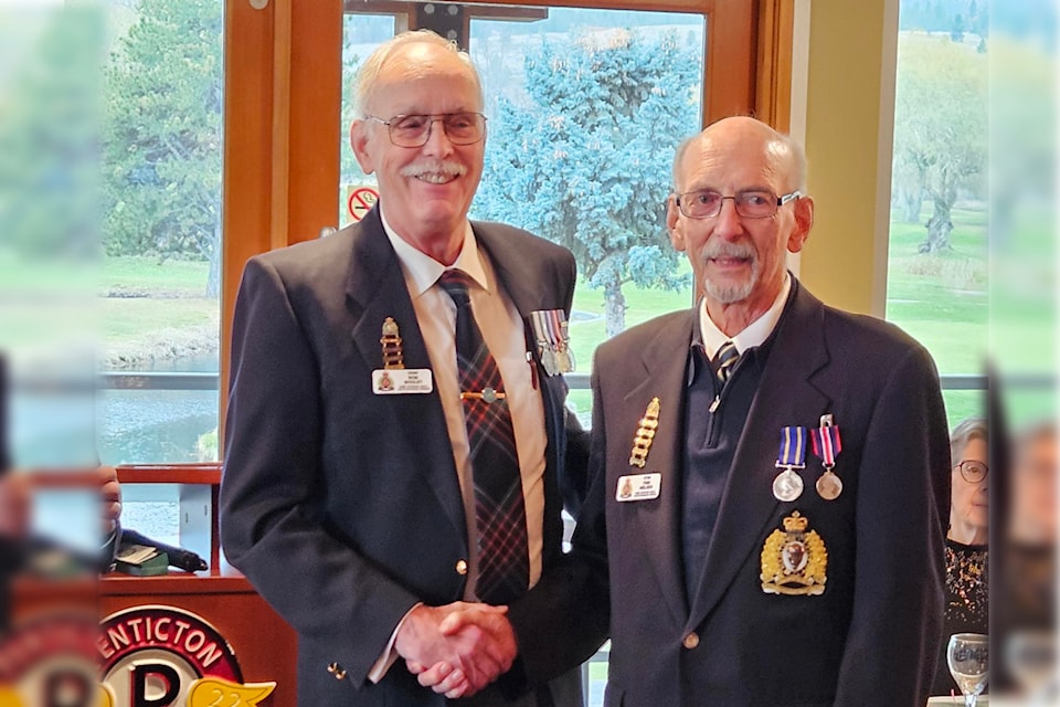 South Okanagan Division of the RCMP Veteran's Association president Rob Boulet, left, shakes hands with Finn Neilsen to congratulate him on receiving the King Charles Coronation Medal for contributions to the community and region.  